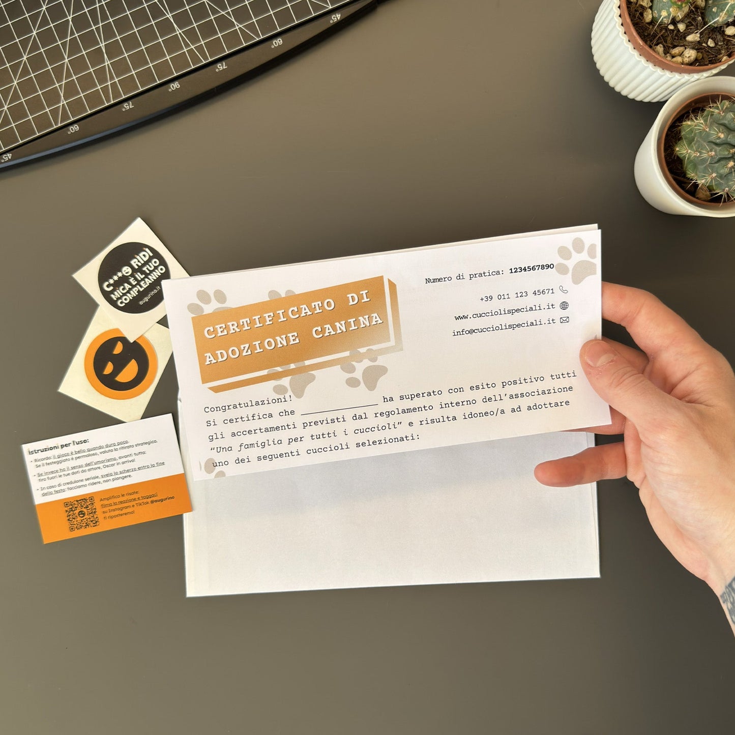 Mockup ironico di augurino del finto voucher per adozione di cani diversamente belli con nomi stravaganti e divertenti