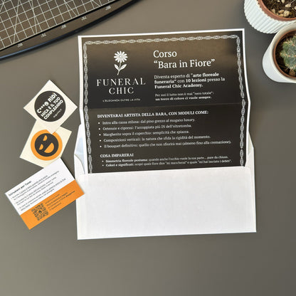 Foto prodotto del finto voucher per il corso per diventare esperti di arte floreale funeraria con busta per lettere