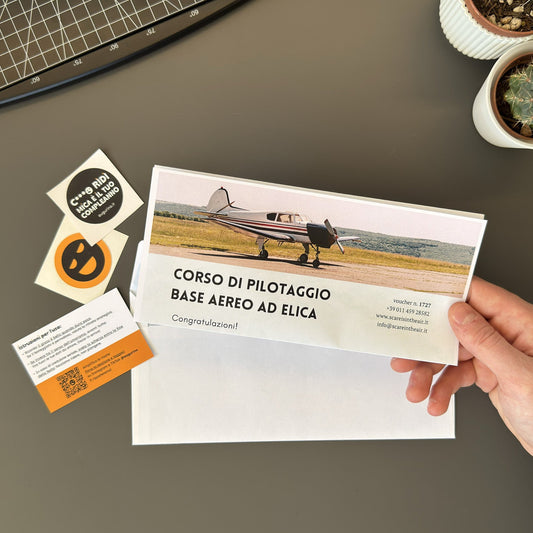 foto prodotto del finto voucher per corso di pilotaggio aereo ad elica tenuto in mano