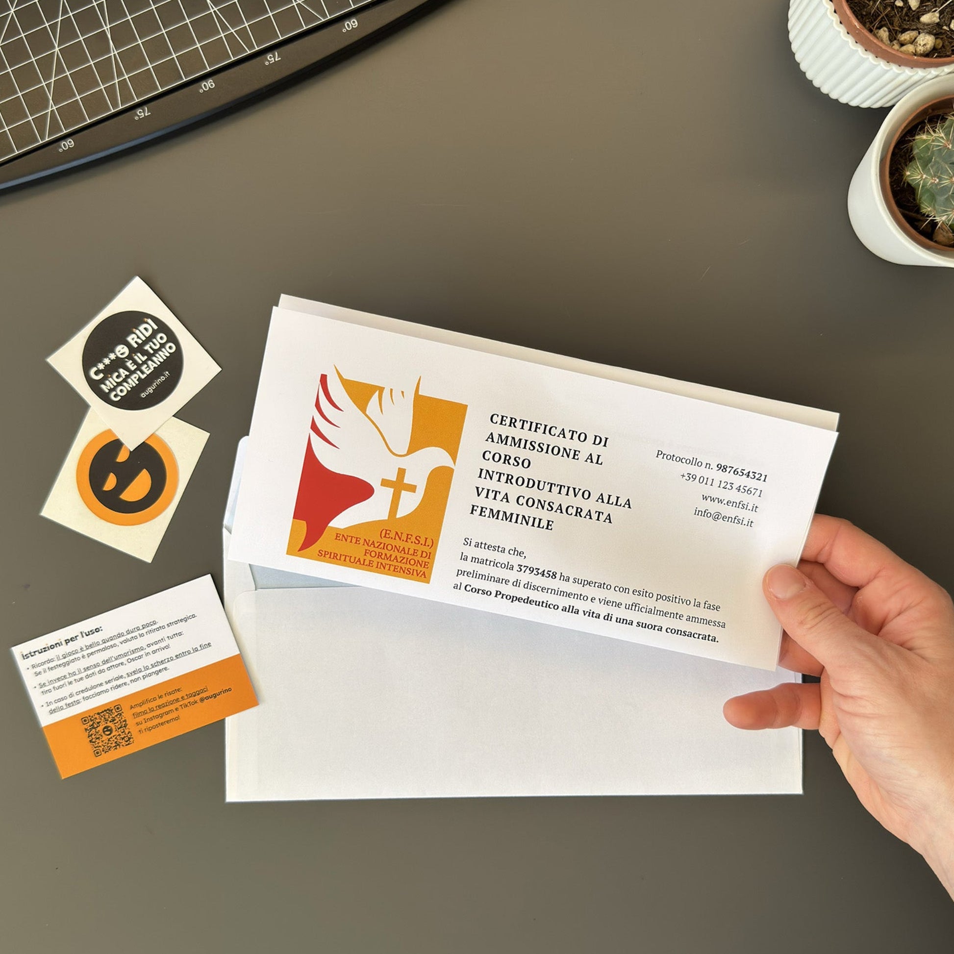 Foto di augurino del finto voucher per ammissione al percorso spirituale per diventare suora tenuto in mano