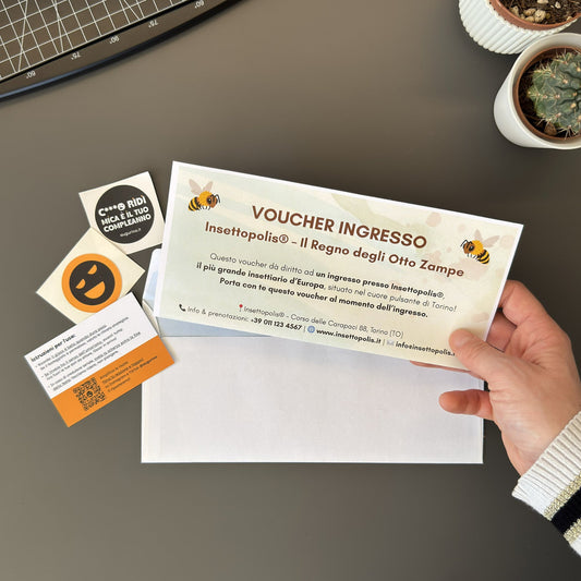 Foto prodotto del finto voucher per una visita all'insettiario più grande d'europa per persone che hanno la fobia degli insetti tenuto tra le mani