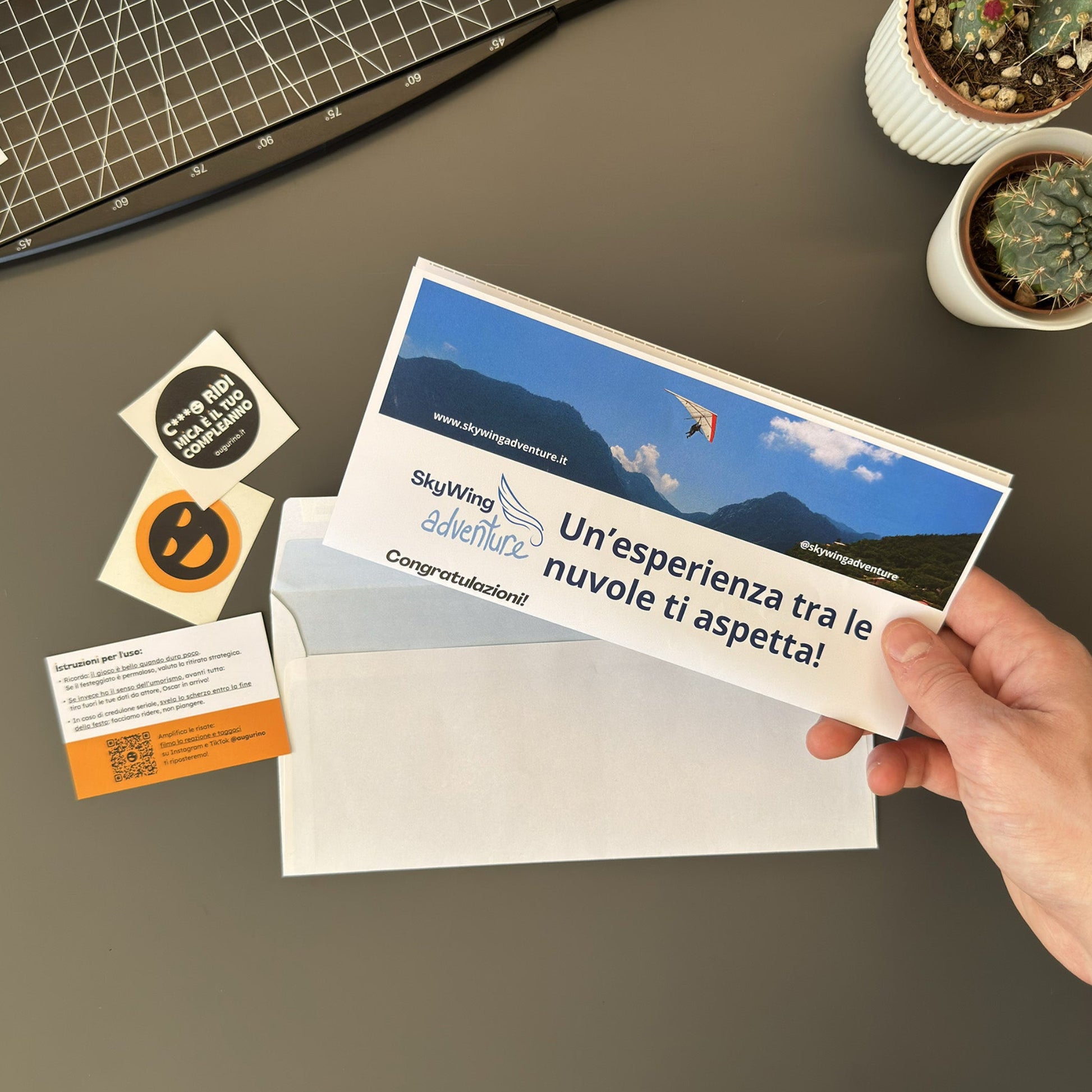 Foto prodotto finto voucher volo in deltaplano tenuto in mano piegato