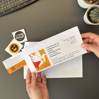 Foto prodotto di augurino del finto voucher per ammissione al percorso spirituale per diventare sacerdoti tenuto in mano